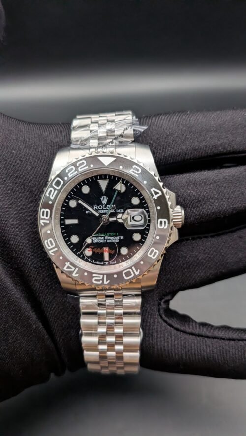 Rolex — esfera negra con doble huso horario, bisel gris y negro y brazalete de acero