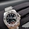 Rolex — esfera negra con doble huso horario, bisel gris y negro y brazalete de acero
