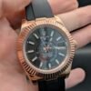 Rolex — esfera gris oscura con calendario anual, caja oro rosa y correa de caucho negra