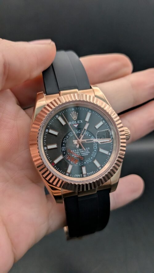 Rolex — esfera gris oscura con calendario anual, caja oro rosa y correa de caucho negra