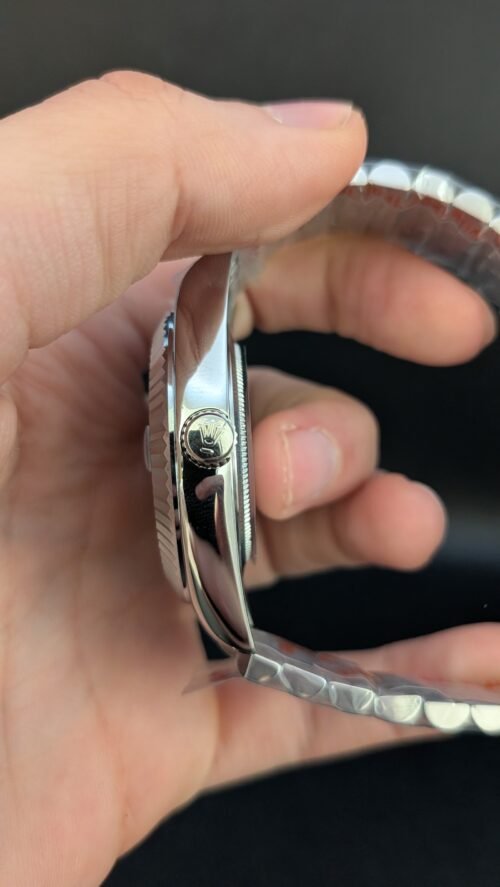 Rolex — esfera gris con números romanos verdes, bisel estriado y brazalete jubilee de acero