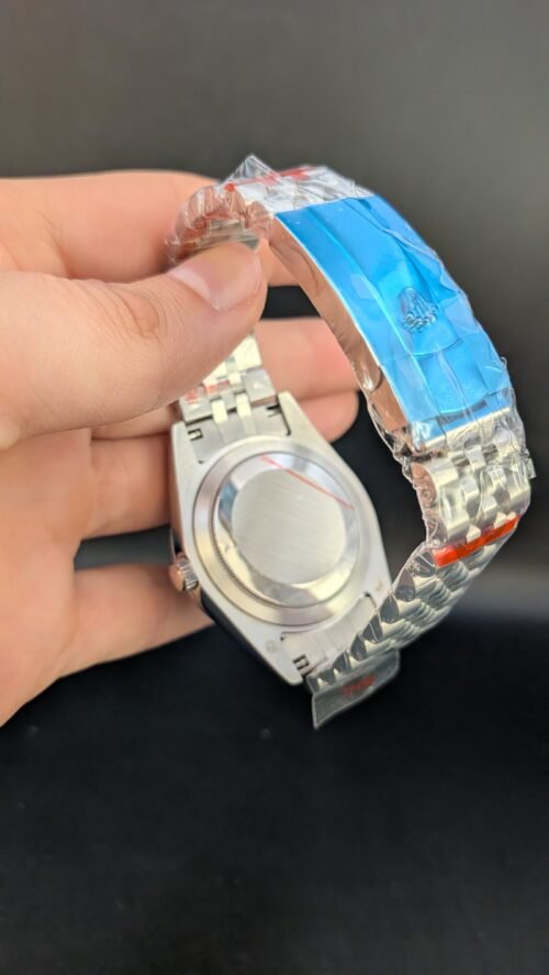 Rolex — esfera gris con números romanos verdes, bisel estriado y brazalete jubilee de acero