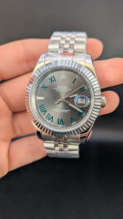 Rolex — esfera gris con números romanos verdes, bisel estriado y brazalete jubilee de acero