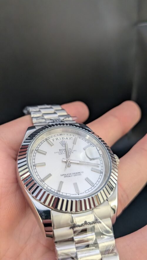 Rolex — esfera plateada con día y fecha, bisel estriado y brazalete de acero