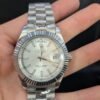 Rolex — esfera plateada con día y fecha, bisel estriado y brazalete de acero