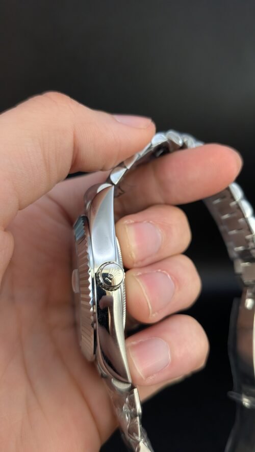 Rolex — esfera plateada con día y fecha, bisel estriado y brazalete de acero