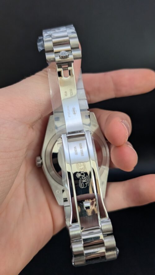 Rolex — esfera plateada con día y fecha, bisel estriado y brazalete de acero