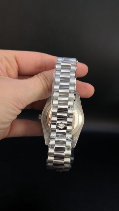 Rolex — esfera verde con números romanos, día y fecha, bisel estriado y brazalete de acero