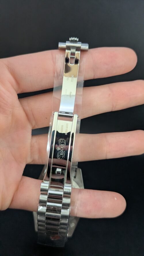 Rolex — esfera verde con números romanos, día y fecha, bisel estriado y brazalete de acero