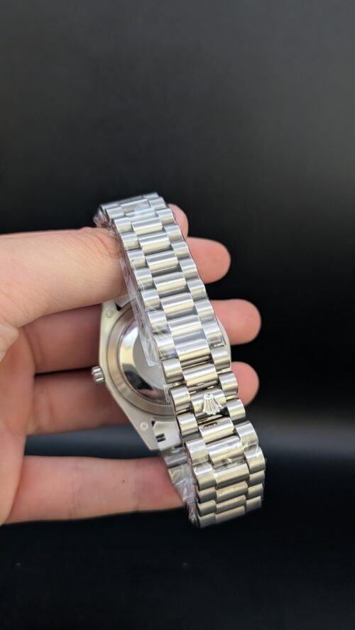 Rolex — esfera azul hielo con números romanos, día y fecha, bisel estriado y brazalete de acero