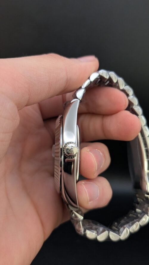 Rolex — esfera azul hielo con números romanos, día y fecha, bisel estriado y brazalete de acero