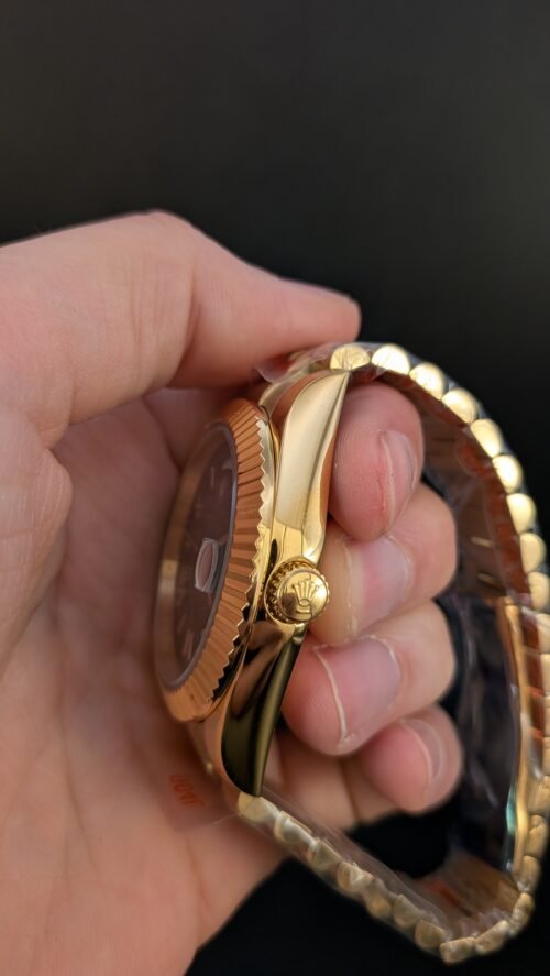 Rolex — esfera verde degradada con números romanos, día y fecha, caja y brazalete dorados