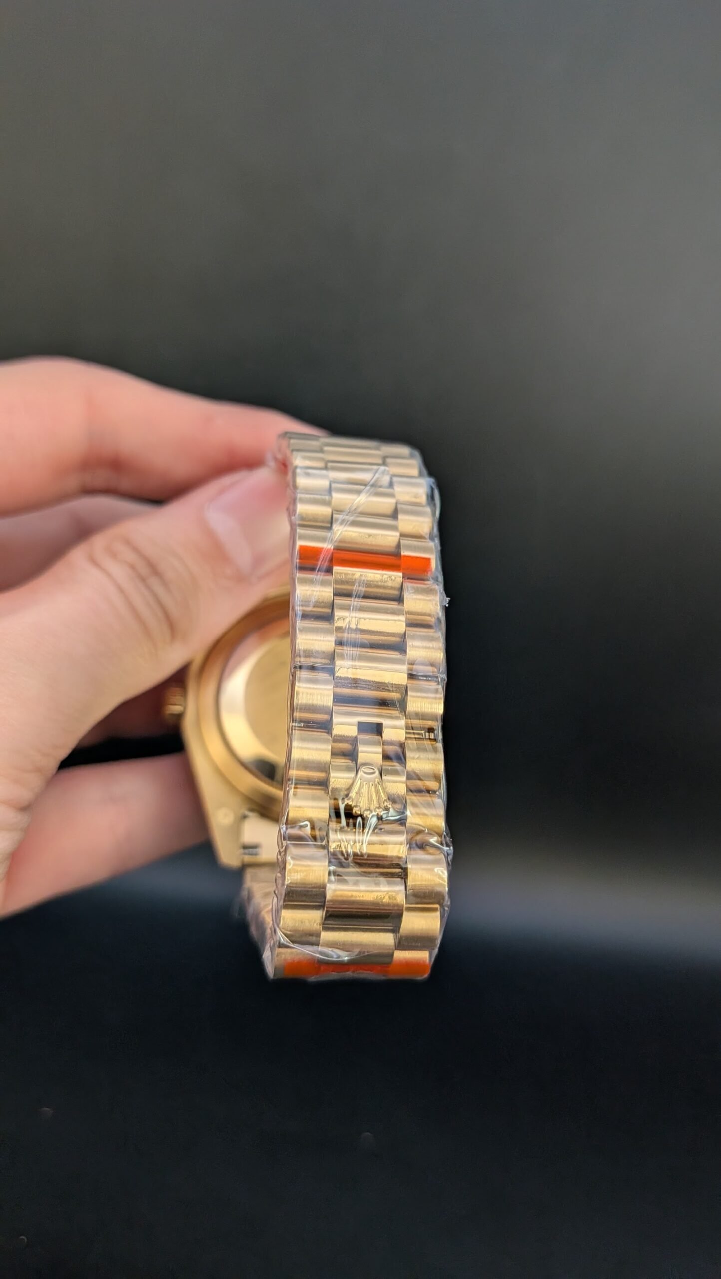 Rolex — esfera verde degradada con números romanos, día y fecha, caja y brazalete dorados
