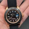 Rolex — esfera negra, bisel negro, caja oro rosa y correa de caucho negra
