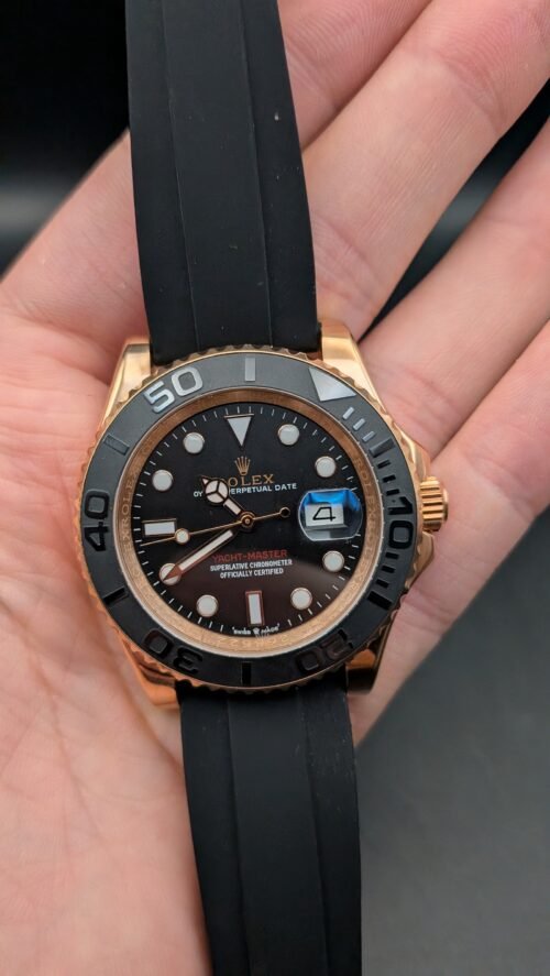 Rolex — esfera negra, bisel negro, caja oro rosa y correa de caucho negra