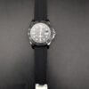 Rolex — esfera negra, bisel gris, caja de acero y correa de caucho negra