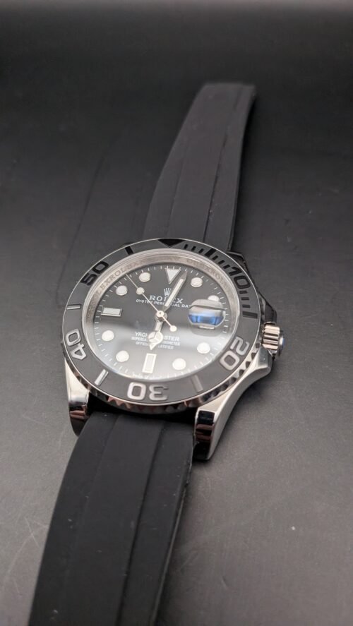 Rolex — esfera negra, bisel gris, caja de acero y correa de caucho negra