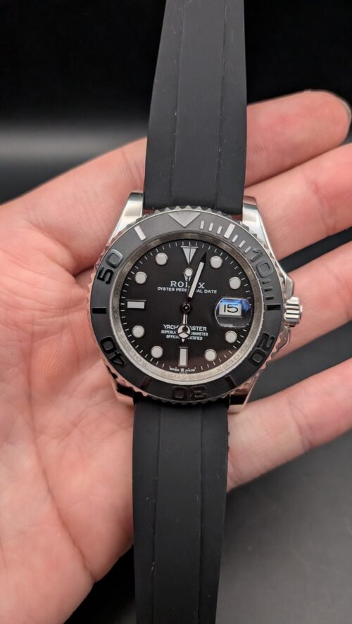 Rolex — esfera negra, bisel gris, caja de acero y correa de caucho negra