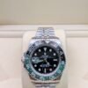 Rolex — esfera negra con doble huso horario, bisel verde y negro y brazalete jubilee de acero