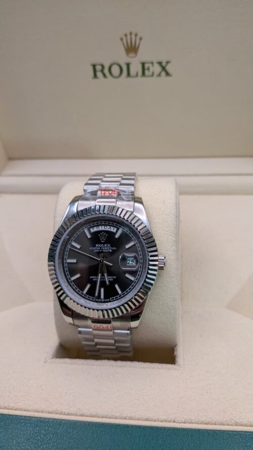 Rolex — esfera negra con día y fecha, bisel estriado y brazalete de acero