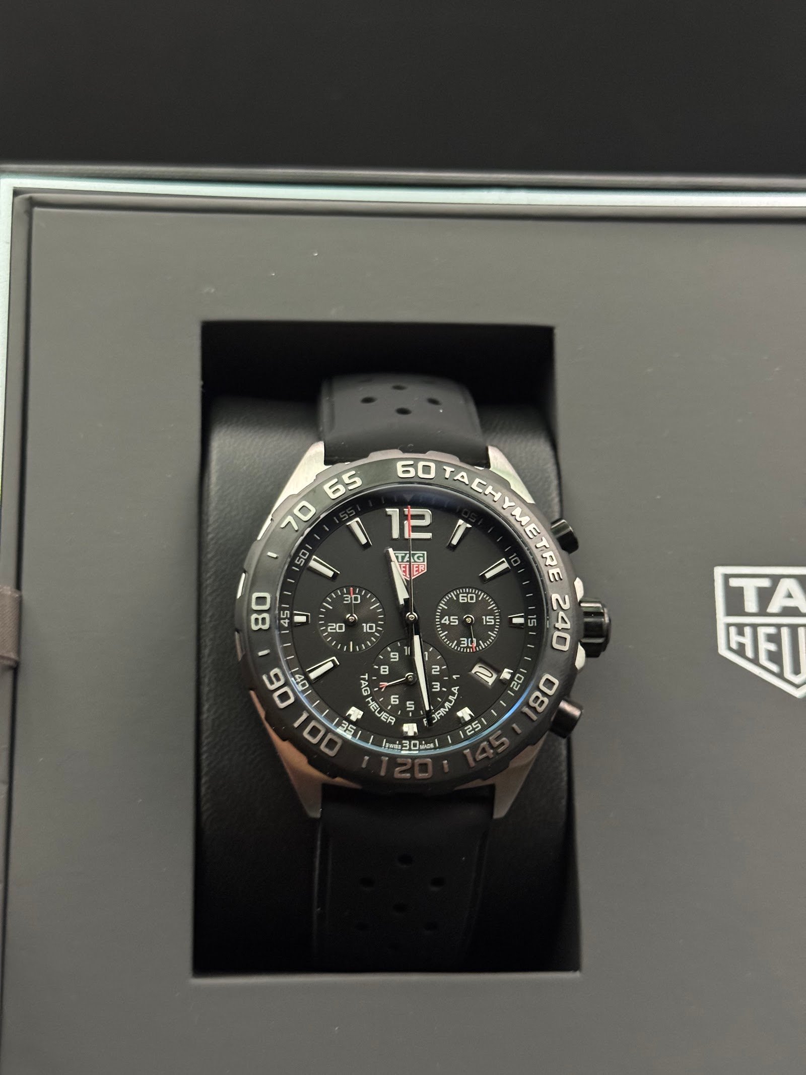 TAG Heuer — cronógrafo con esfera negra, bisel negro y correa de caucho negra
