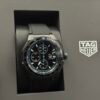 TAG Heuer — cronógrafo con esfera negra y detalles azules, correa de caucho negra