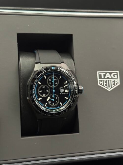 TAG Heuer — cronógrafo con esfera negra y detalles azules, correa de caucho negra
