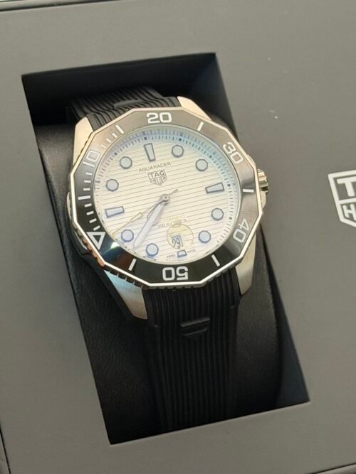 TAG Heuer — esfera blanca texturizada, bisel negro y correa de caucho negra