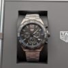 TAG Heuer — cronógrafo con esfera negra, bisel negro y brazalete de acero