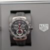TAG Heuer — cronógrafo con esfera negra y detalles rojos, correa de caucho negra