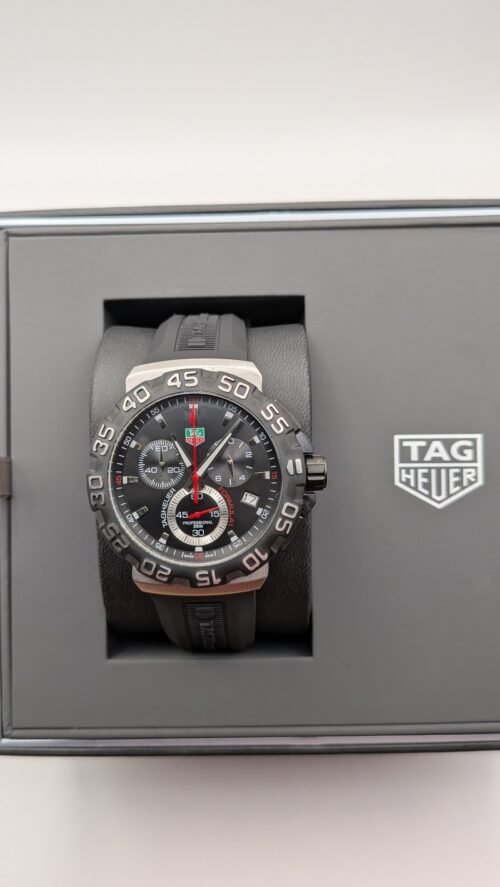 TAG Heuer — cronógrafo con esfera negra y detalles rojos, correa de caucho negra