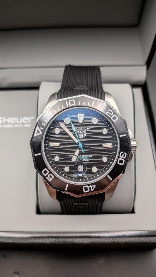 TAG Heuer — esfera negra ondulada con detalle celeste, bisel negro y correa de caucho negra
