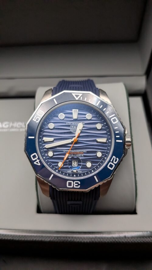 TAG Heuer — esfera azul ondulada con detalle naranja, bisel azul y correa de caucho azul