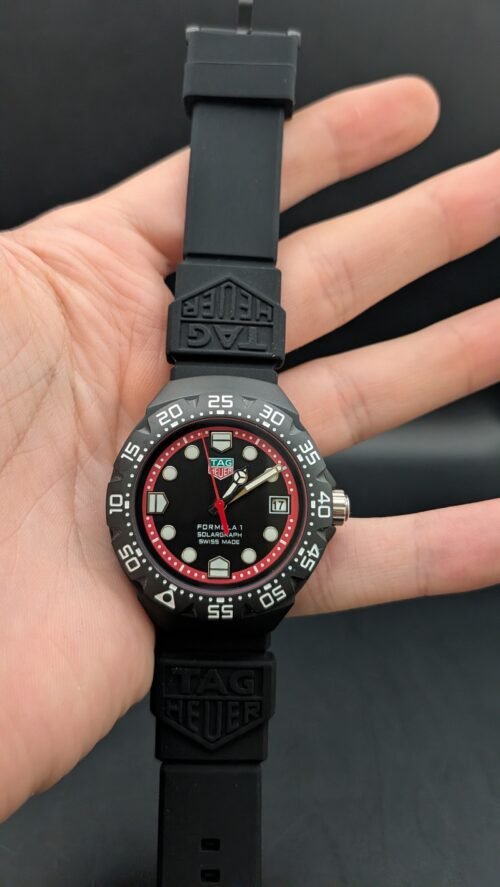 TAG Heuer — esfera negra con aro rojo, caja negra y correa de caucho negra