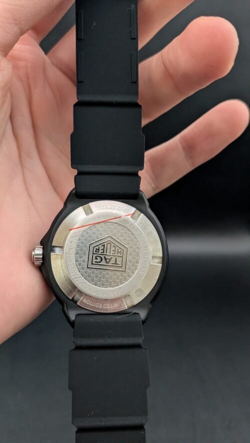 TAG Heuer — esfera negra con aro rojo, caja negra y correa de caucho negra