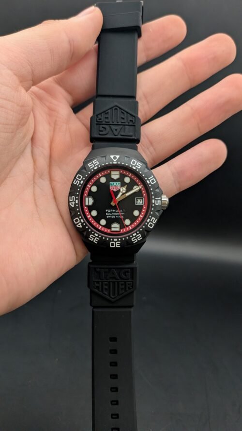 TAG Heuer — esfera negra con aro rojo, caja negra y correa de caucho negra