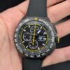 TAG Heuer — cronógrafo con esfera negra y detalles amarillos, caja negra y correa de caucho negra