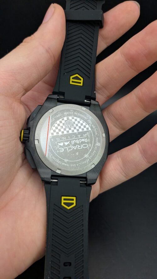 TAG Heuer — cronógrafo con esfera negra y detalles amarillos, caja negra y correa de caucho negra