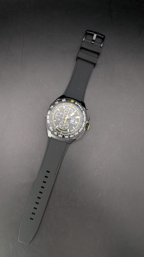 TAG Heuer — cronógrafo con esfera negra y detalles amarillos, caja negra y correa de caucho negra