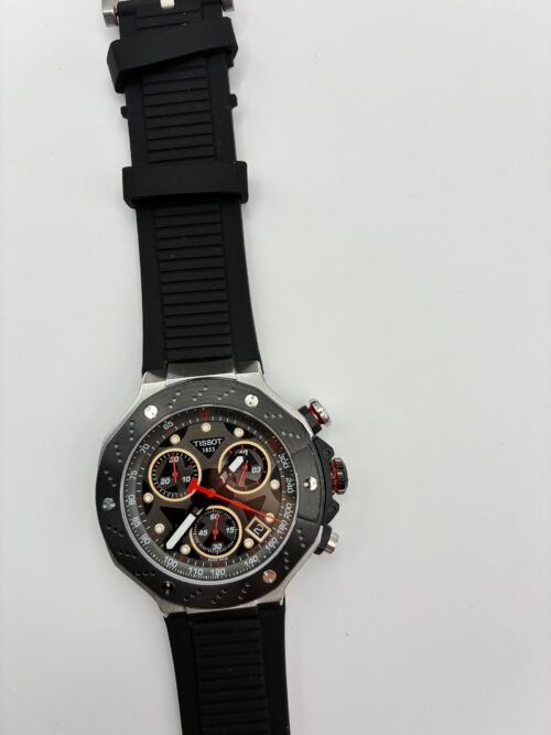 Tissot — cronógrafo con esfera negra y aros dorados, caja de acero y correa de caucho negra