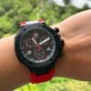 Tissot — cronógrafo con esfera negra y detalles rojos, caja negra y correa de caucho roja