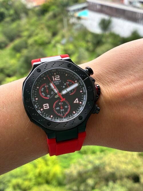 Tissot — cronógrafo con esfera negra y detalles rojos, caja negra y correa de caucho roja