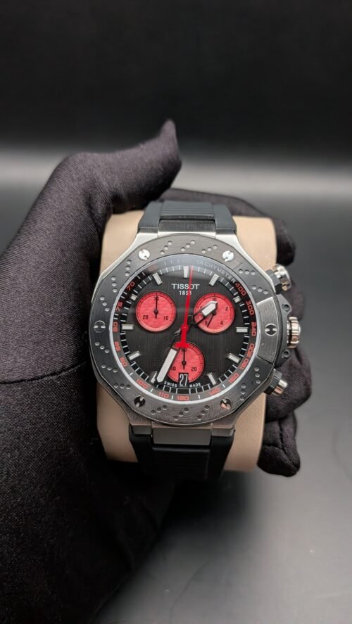 Tissot — cronógrafo con esfera negra y subesferas rojas, caja de acero y correa negra