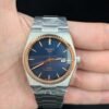 Tissot — esfera azul, bisel oro rosa estriado y brazalete de acero