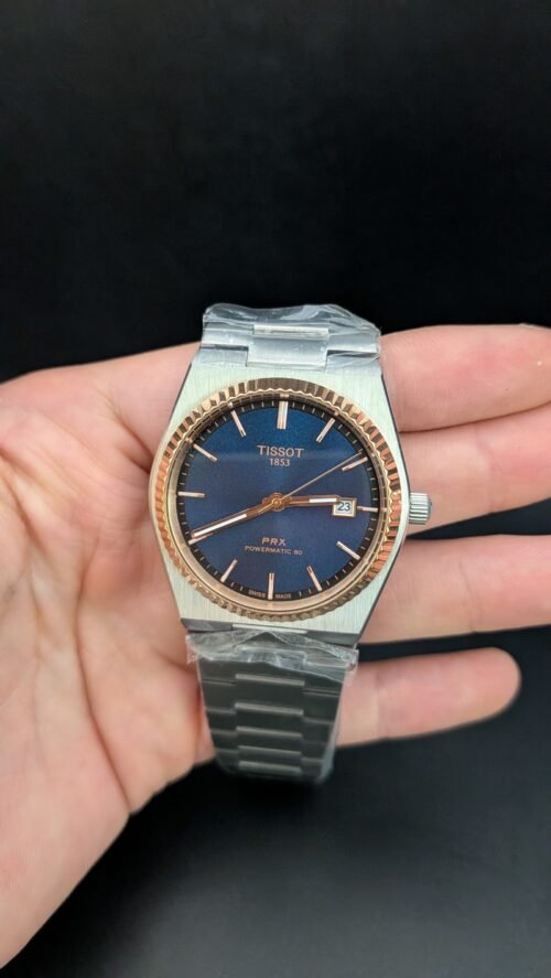 Tissot — esfera azul, bisel oro rosa estriado y brazalete de acero