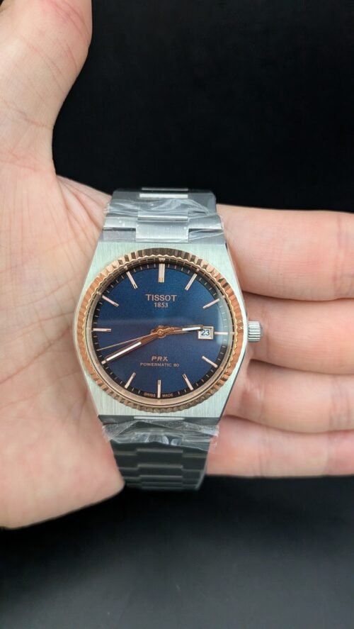 Tissot — esfera azul, bisel oro rosa estriado y brazalete de acero