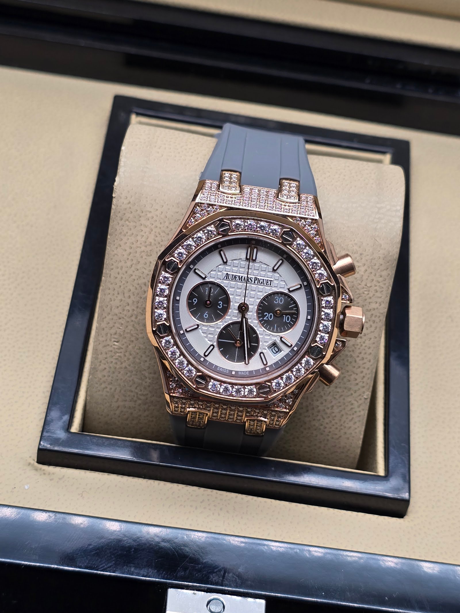 Audemars Piguet — cronógrafo con esfera blanca y subesferas negras, caja oro rosa con brillantes y correa gris