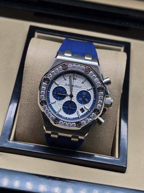 Audemars Piguet — cronógrafo con esfera blanca y subesferas azules, bisel con brillantes y correa azul