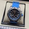 Breitling — cronógrafo con esfera negra, detalles azules, caja de acero y correa azul celeste