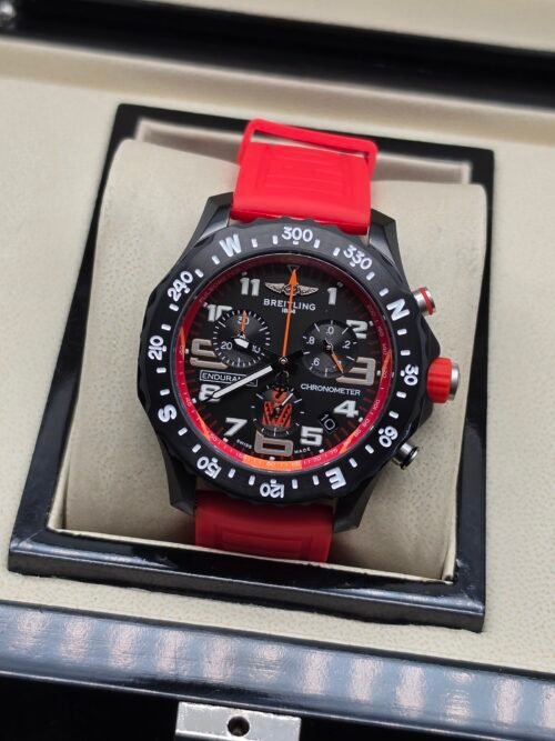 Breitling — cronógrafo negro con detalles rojos y correa roja